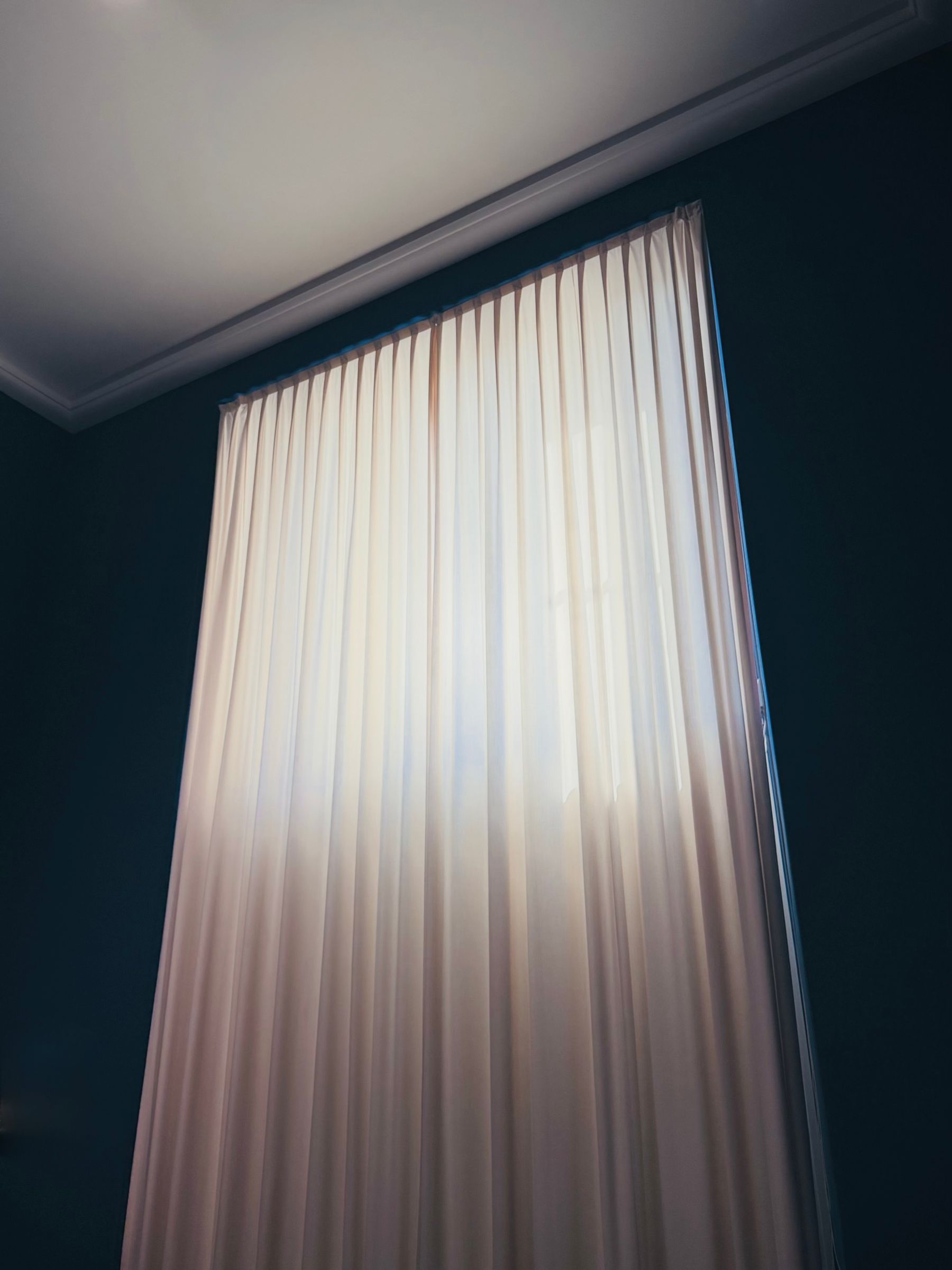 Daylight diffusing through a sheer curtain in a quiet room